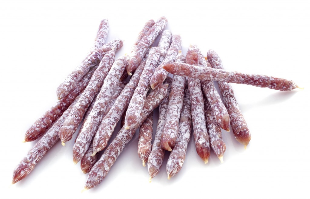 sticks of saucisson in front of white background